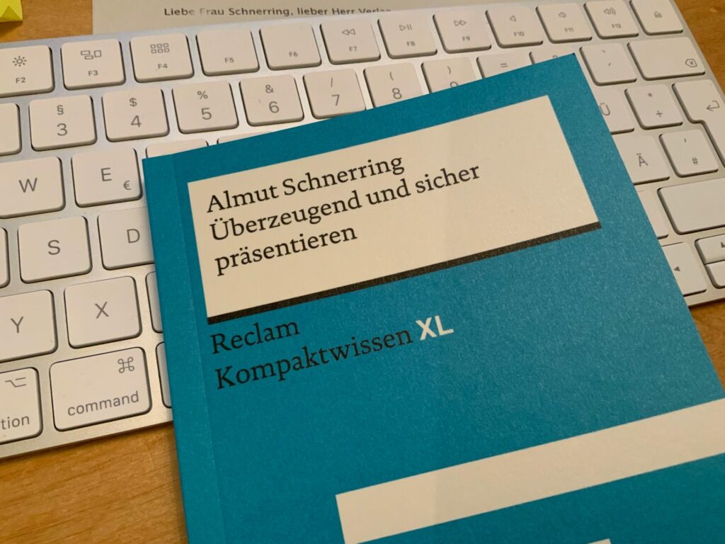Cover blaues Reclam Buch auf ComputerTastatur